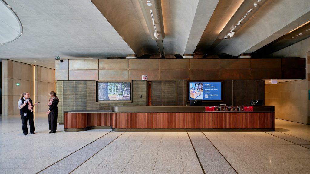 Modern lobby with two people at a reception desk.